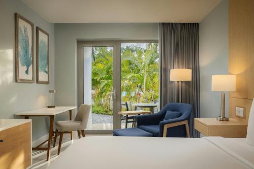 a hotel room with a bed and a desk and chairs at Courtyard by Marriott Aruba Resort in Palm-Eagle Beach