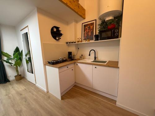a kitchen with white cabinets and a sink at suite Jacuzzi terrasse privé parking in Caligny