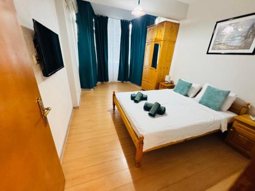 a bedroom with a bed with blue pillows on it at Apartment Nencheva in Sandanski