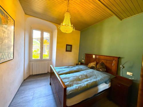 a bedroom with a bed and a chandelier at Casa Claudia Pieve centro storico in Tremosine Sul Garda