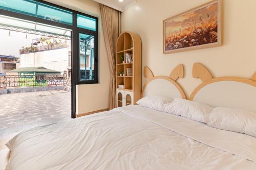 a bedroom with a large white bed and a window at Willow Stay in Hai Phong