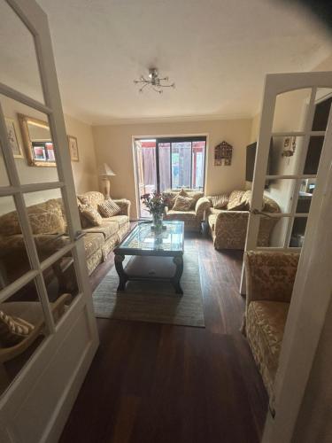 a living room with a couch and a table at Stylish Home With Full Amenities in Yiewsley