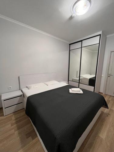 a bedroom with a large bed and a mirror at Apartament modern cu dormitor separat si balcon panoramic in Căuşeni