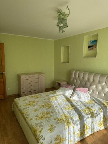a bedroom with a large bed and a dresser at Teatra 34-31 in Daugavpils
