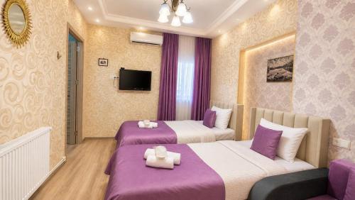 a hotel room with two beds and a couch at Bereka Apartment in Mtskheta in Mtskheta