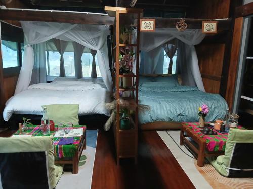 a bedroom with two beds and a table and chairs at Ha Giang Uphill Coffee Farmstay in Ha Giang