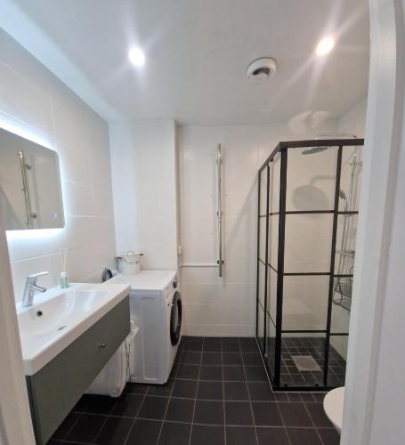 a bathroom with a sink and a washing machine at Central City Apartment A in Nyköping