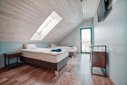 a attic bedroom with two beds and a skylight at Willa Gostomko in Gostomko