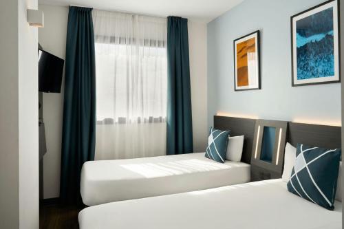 a bedroom with two beds and a window at Four Points Flex by Sheraton Malaga Centre in Málaga