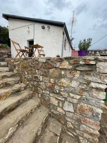 a stone wall in front of a white house at Sterna in Mesovounion-Zagori