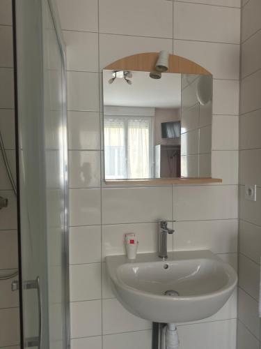 a white bathroom with a sink and a mirror at Hostellerie de la juhel in Villaines-la-Juhel