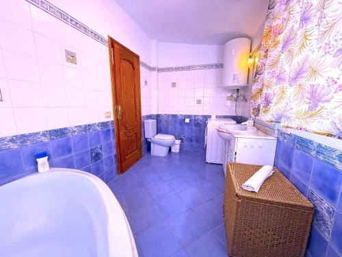 a blue and white bathroom with a tub and a toilet at Tropicalidays Oceanview Chayofa in Chayofa