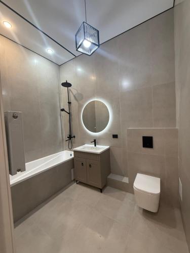 a bathroom with a tub and a sink and a toilet at Designer Apartment with Mountain View in Almaty