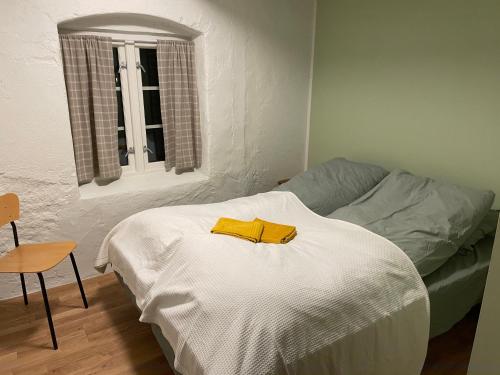 a bedroom with a bed with a yellow robe on it at Ner-Grefstad gard in Kallstad