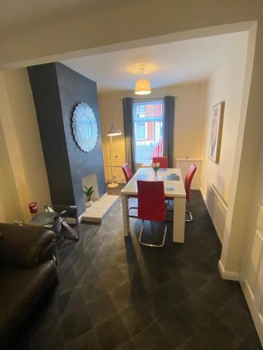 a living room with a table and red chairs at spamount house in Belfast