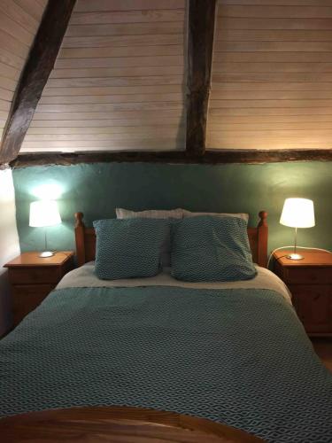 a bedroom with a green bed with two lamps at Tour médiévale in Saint-Georges-de-Luzençon
