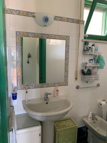a bathroom with a sink and a mirror at Arcadia Case e Vacanze in Lacco Ameno