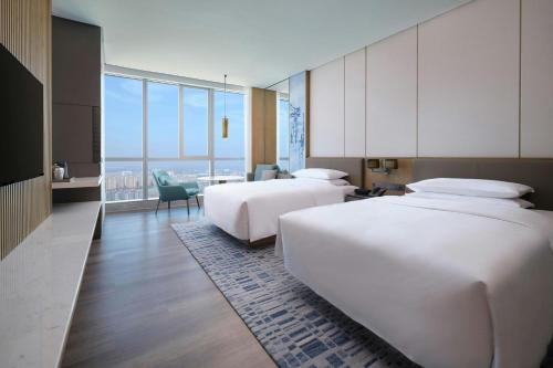 two beds in a hotel room with a view at Huzhou Marriott Hotel Nanxun in Huzhou