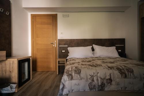 a bedroom with a bed and a television at Albergo Pineta dal 1891 in Villetta Barrea