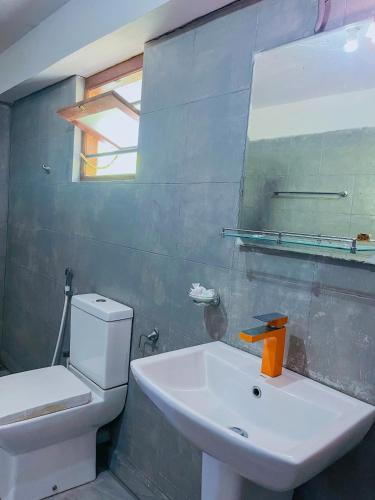 a bathroom with a sink and a toilet and a mirror at Home in the Island in Tangalle