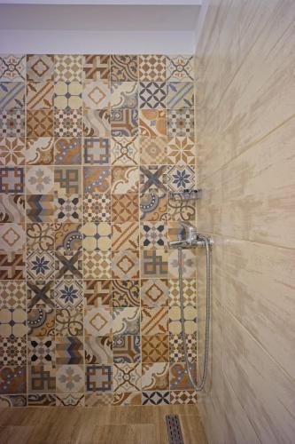 a bathroom with a shower with a tiled wall at Dimitra Apartments in Kanali