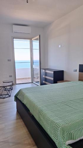 a bedroom with a bed and a view of the ocean at A-mare Casa vacanza in Gagliano del Capo