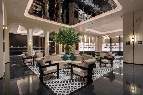 a lobby with a couch and a table and chairs at Dream Palace Ben Thanh Grand Hotel in Ho Chi Minh City
