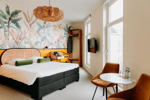 a bedroom with a bed and a table and chairs at La Paulowna Boutique Hotel in The Hague