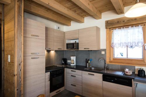 a kitchen with wooden cabinets and a sink and a window at Les Adrets in Gérardmer