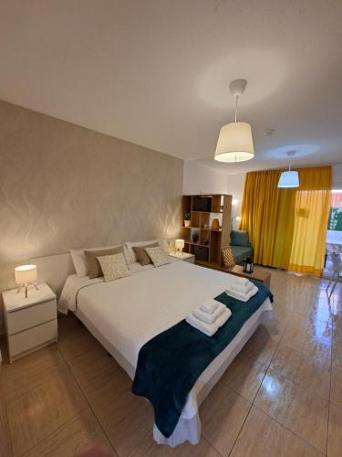 a bedroom with a large bed with towels on it at Apartamento ELIDE in Costa Del Silencio