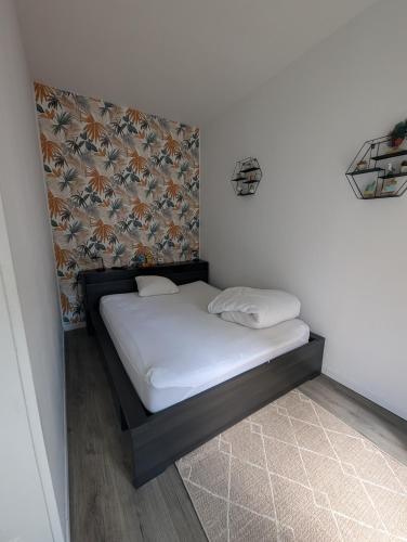 a small bed in a corner of a room at La parenthèse in Ault