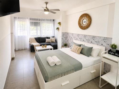 a bedroom with a large bed and a living room at Casa rody in Benalmádena
