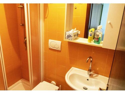 a bathroom with a sink and a toilet and a mirror at Sotto il Pino 14 in Eraclea Mare