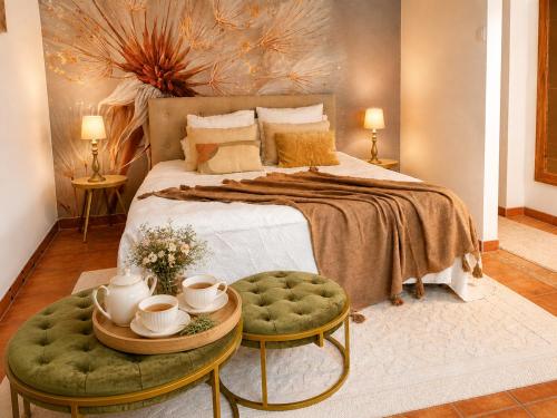 a bedroom with a large bed with a green ottoman at Salvacintoggio -Votre Villa avec Piscine Privée- in Porto-Vecchio