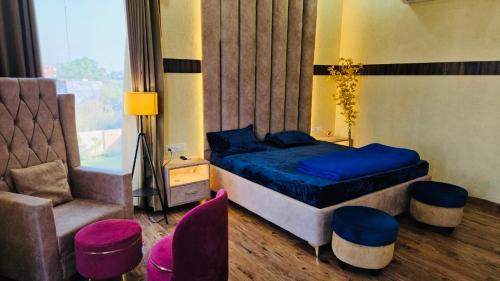 a bedroom with a bed and a couch and a chair at Lux Bliss Bed & Breakfast in Amritsar