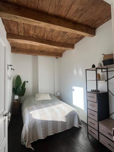 a bedroom with a bed and a wooden ceiling at Anaky rider nomade in Curvalle