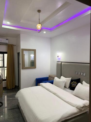a bedroom with two beds with purple lights on the ceilings at Fimdah Hotel in Dushepe