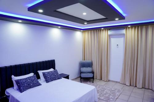 a hotel room with a bed and a chair at Villa BBS in Ghlissia