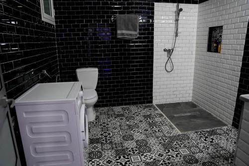 a black and white bathroom with a toilet and a shower at Villa BBS in Ghlissia