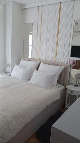 a bedroom with a bed with white sheets and pillows at Uzdrowiskowa "Trzy Korony" in Świnoujście