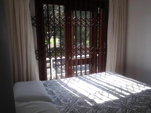 a bedroom with a bed and a window with a gate at Casa Ditesta in Caxias do Sul