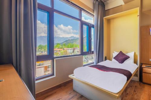 a bedroom with a bed and a large window at Hotel New Mamta in Srinagar
