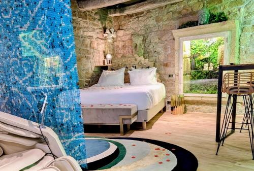 a bedroom with a bed in a room with a window at Les suites du Bouddha Bleu in Carnac