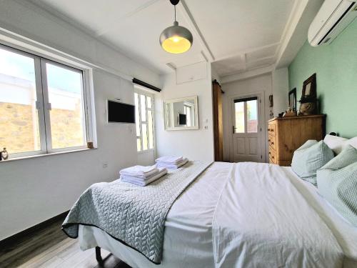 a bedroom with a white bed with towels on it at Xenia Studios in Piskokéfalon