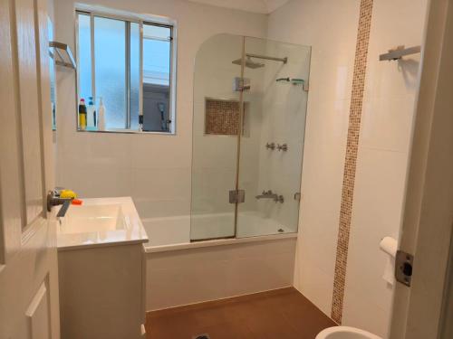 a white bathroom with a shower and a sink at Bright Double Room N Winston Hills in Toongabbie