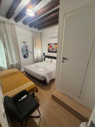a bedroom with a bed and a chair in it at Experience Hotel Antico Capon in Venice