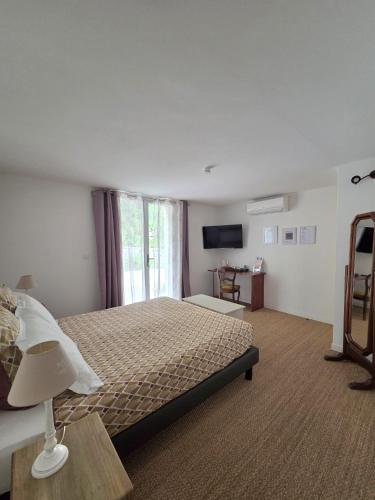 a large bedroom with a bed and a window at Villa Manoe in Draguignan