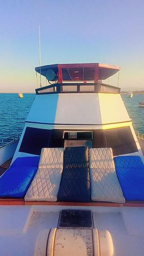 ein Boot mit blau-weißen Sitzen auf dem Wasser in der Unterkunft Yosr in Hurghada