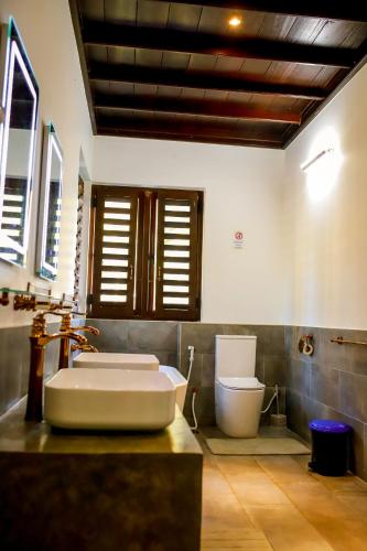 a bathroom with a sink and a toilet at Nayan's Paradise in Kottanitivu