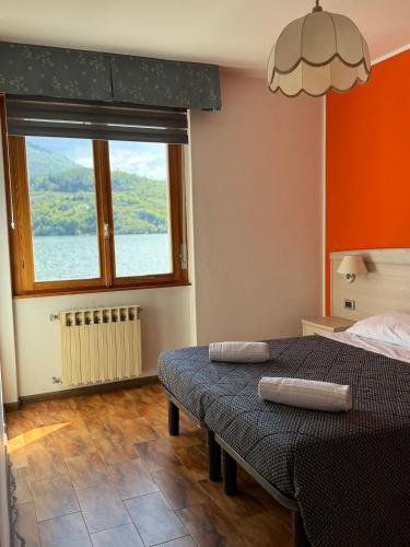 a bedroom with a bed and a large window at Hotel Mezzolago in Calceranica al Lago